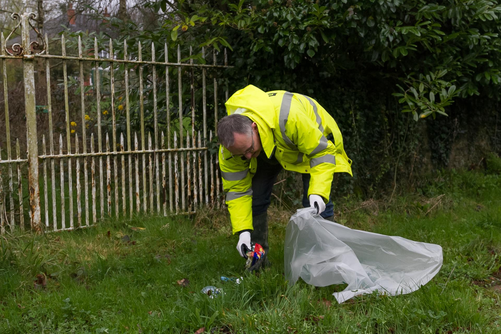 A man picks up litter near Barringtons Bridge