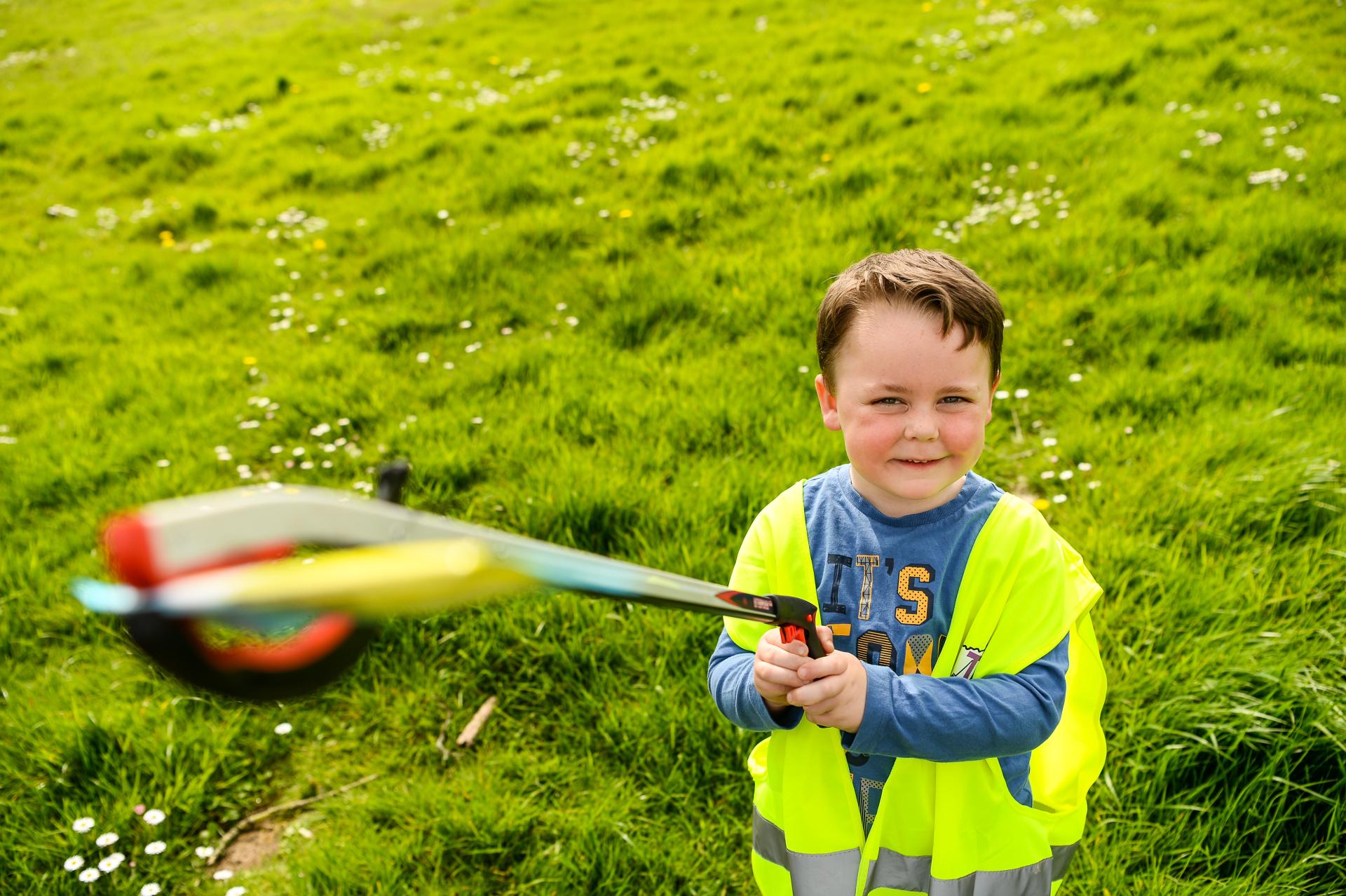 A child with a litter picker holding rubbish